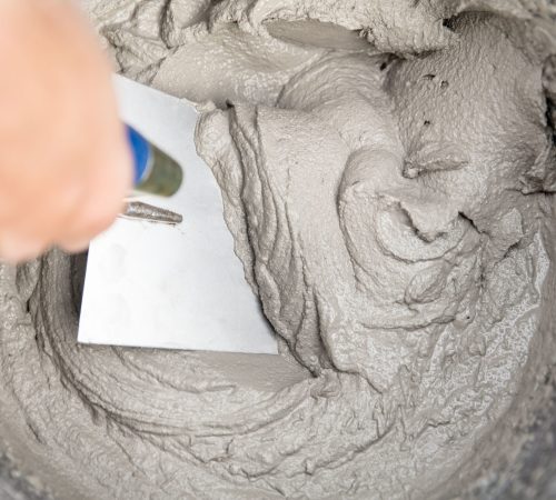 Nahaufnahme von frisch gemischtem Beton mit Kelle – gewaschener Quarzsand von Quarzwerke Friedl als Zuschlagsstoff für hohe Festigkeit und Verarbeitungseigenschaften