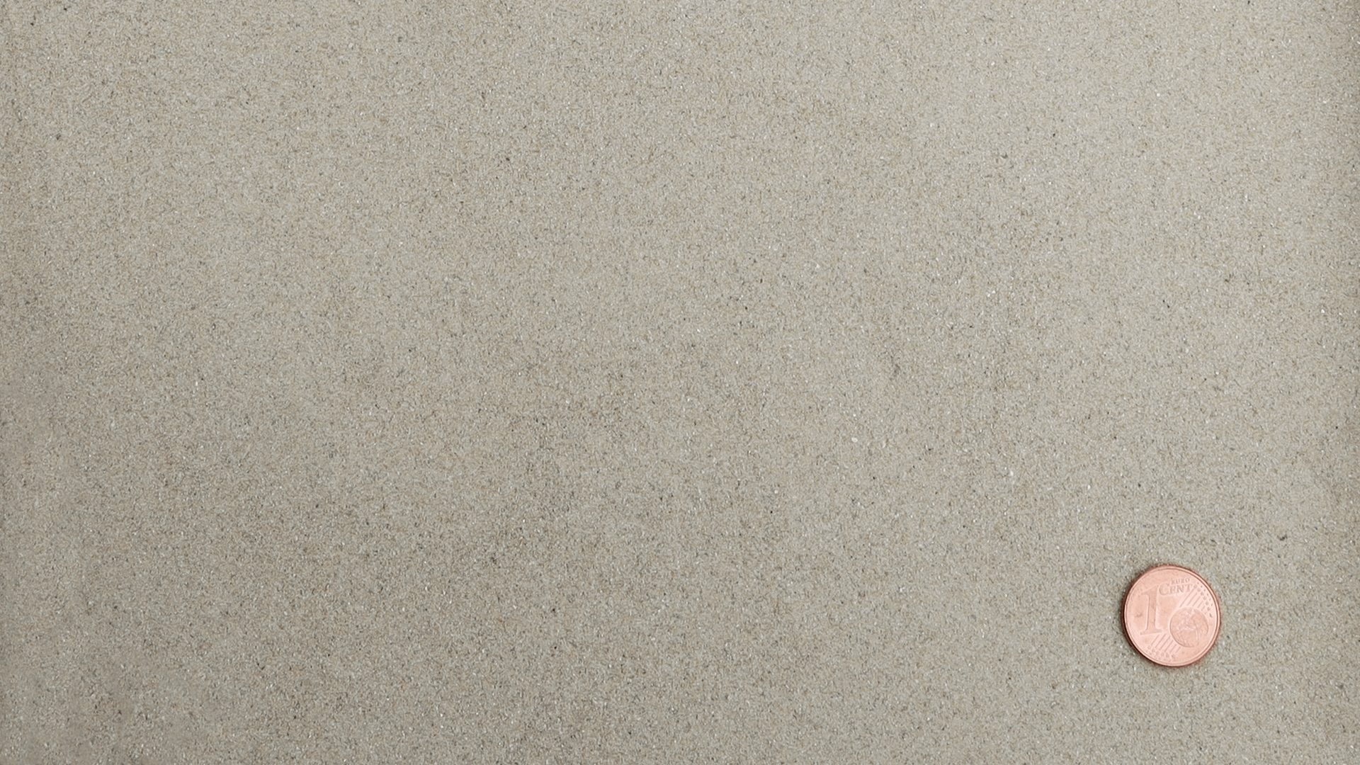 Sehr feiner, hellbeiger gewaschener Quarzsand aus der Produktlinie RK-I-0-1 der Quarzwerke Friedl, dargestellt mit 1-Cent-Münze zum Größenvergleich