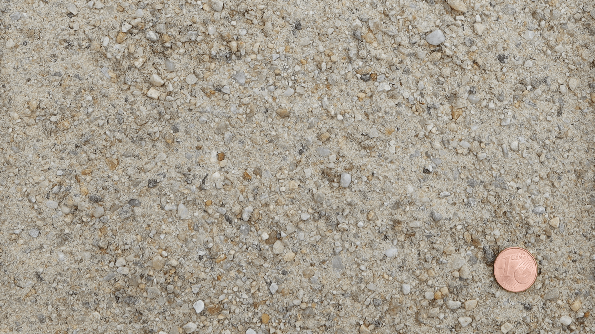 Feiner, ungewaschener Quarzsand aus dem Werk der Quarzwerke Friedl mit Centmünze zur Korngrößenreferenz