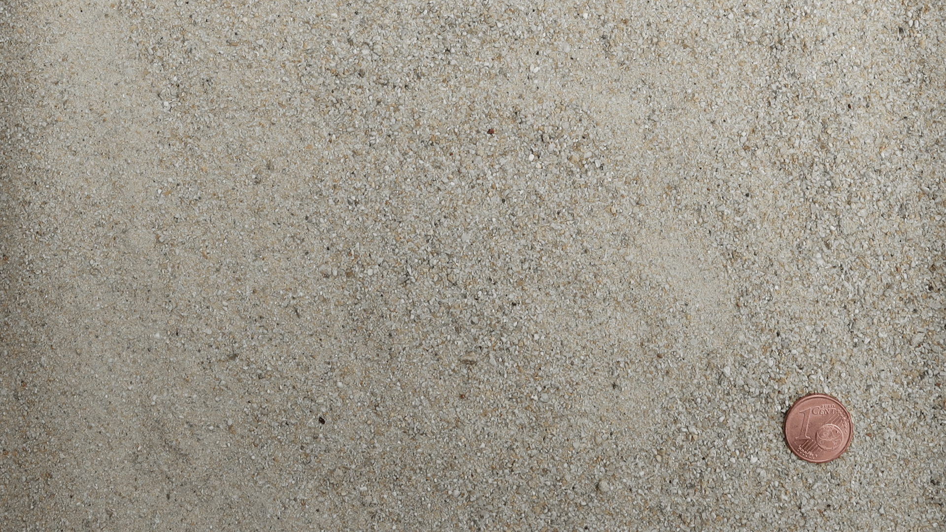 Feinkörniger gewaschener Quarzsand RK I 0,1/0,8 von Quarzwerke Friedl – mit Centmünze zur Veranschaulichung der Korngröße
